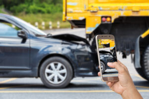 Close up hand of woman holding smartphone and take photo of car accident in Dunwoody, GA